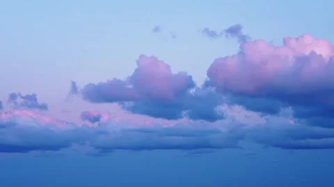Picturesque pink clouds float slowly across sunrise sky Stock Footage