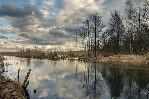 Picturesque spring cloudy landscape with a reflection of the dramatic sky in Stock Photos