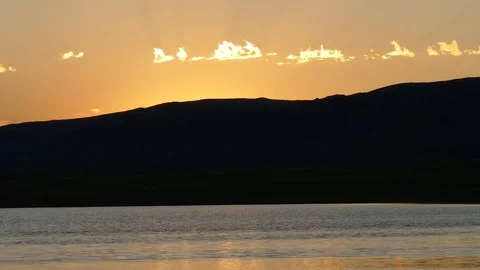 A picturesque sunset with sun rays - the shore of the lake and the mountains. Stock Footage 80091125