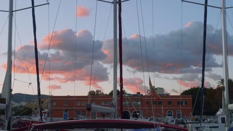Picturesque view of big pink clouds and masts of yachts during sunset in Stock Footage 83877761
