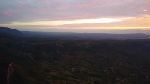 Picturesque view of a mountain range and valley under a colorful sky at sunset Stock Footage 316947917