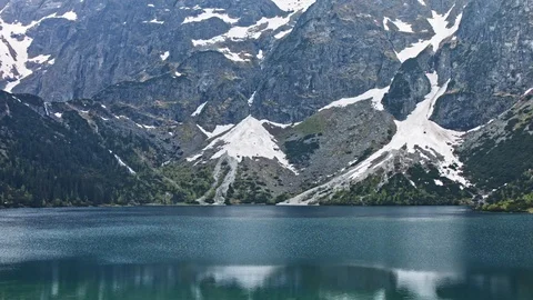 Picturesque view of the snow-capped stony rocks seen from Lake Stock Footage 119831780