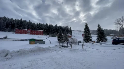 A picturesque winter resort surrounded by snow-covered trees and hills. Cozy bui Stock Footage 296178564