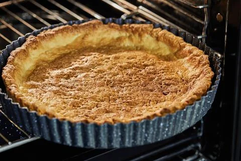 Pie base in metal baking dish after baking in an electric oven Stock Photos