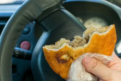 Pie, belyash with meat in the hand of the driver Stock Photos