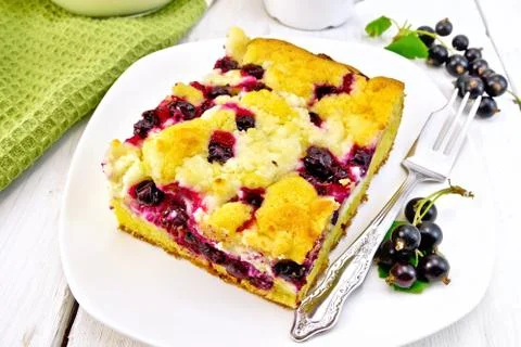 Pie with black currant in plate with fork on light board Stock Photos
