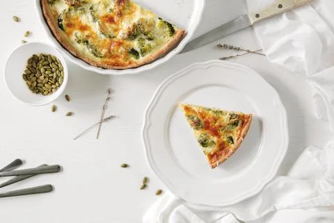 Pie with broccoli, pumpkin pumpkin bite, seeds and crackers lie on a white table Stock Photos