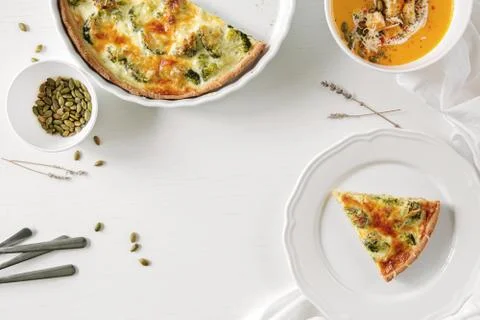 Pie with broccoli, pumpkin pumpkin bite, seeds and crackers lie on a white table Stock Photos