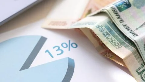 A pie chart is on a piece of paper with a stack of money on top of it Stock Photos