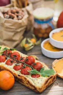Pie with cherry tomatoes, pumpkin pie, orange and paper bag with nuts Stock Photos