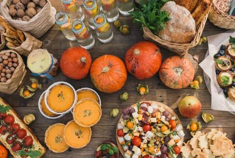 Pie with cherry tomatoes, pumpkin pie, orange and paper bag with nuts Stock Photos