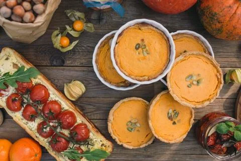 Pie with cherry tomatoes, pumpkin pie, orange and paper bag with nuts Stock Photos
