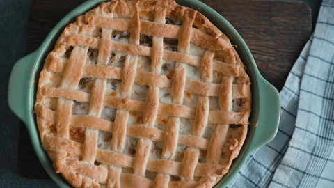 A pie crust is being prepared with a classic lattice design in a kitchen setting Stock Footage 339094751