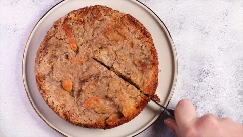 Pie Cuca de Banana on the table. The girl cuts the cake with a knife Stock Footage 240663315