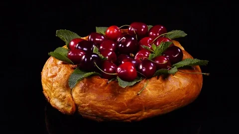 Pie with juicy cherry and mint leaves rotating on black mirror background. 4K 库存影片 78703107