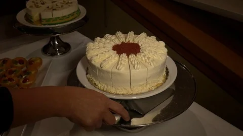 Pie lifter. Female hands are taking piece of care from desserts table. Видео 74288065