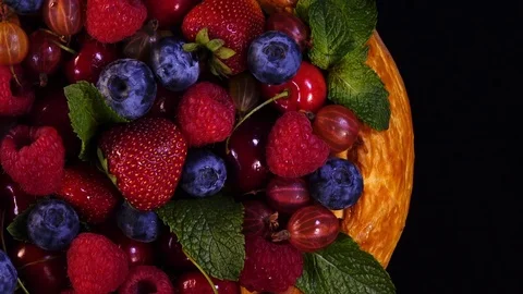 Pie with mixed berries and mint leaves on black background. 4K closeup rotation Vídeos de archivo 77789378