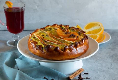 Pie with orange filling. mulled wine on a light background with gray textiles Stock Photos