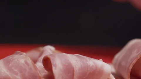Piece of bacon being handled by kitchen staff Stock Footage 128822305