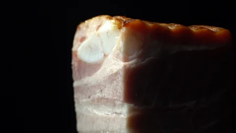Piece of bacon in rotation on a black background, Stock Footage 98968265