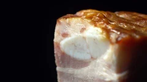 Piece of bacon in rotation on a black background, Stock Footage 98968519