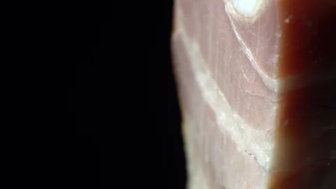 Piece of bacon in rotation on a black background, Stock Footage 98968590