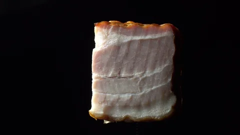 Piece of bacon in rotation on a black background, Stock Footage 98968684