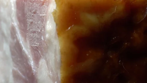 Piece of bacon in rotation on a black background, Stock Footage 98968880