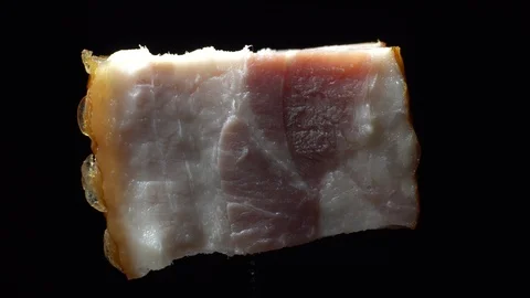Piece of bacon in rotation on a black background, Stock Footage 98968890