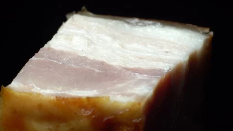 Piece of bacon in rotation on a black background, Stock Footage 98968935