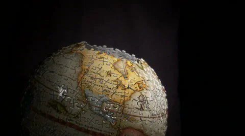 Piece being added to a 3D globe puzzle on black background. Stock Footage 52326234