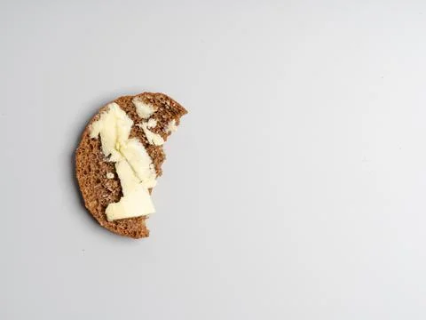 A piece of bread with butter on a light background. Savings concept. hunger Stock Photos