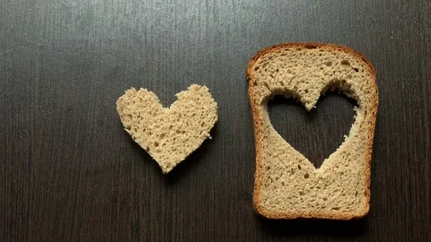 In a piece of bread carved heart on a dark background Stockbeeldmateriaal 103746233