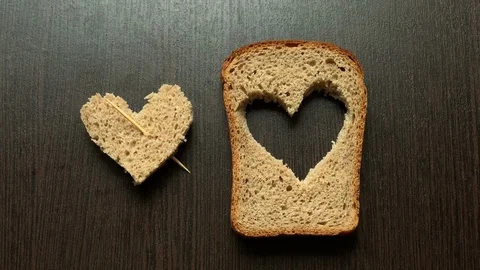 In a piece of bread carved heart on a dark background Stockbeeldmateriaal 103749652