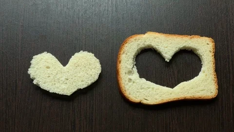 In a piece of bread carved heart on a dark background Stock Footage 103753009