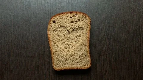 In a piece of bread carved heart on a dark background 库存影片 103759293