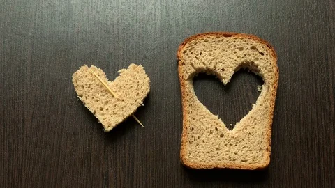 In a piece of bread carved heart on a dark background Stock Footage 103761240