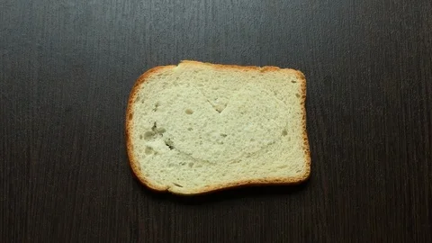 In a piece of bread carved heart on a dark background Stockbeeldmateriaal 103765467