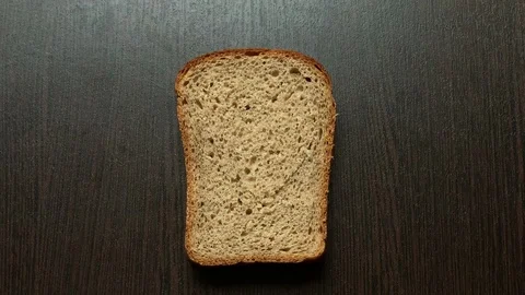In a piece of bread carved heart on a dark background Stockbeeldmateriaal 103772273