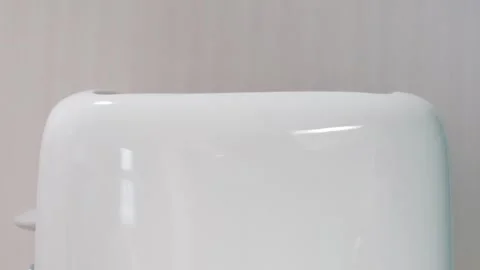 Piece of bread pops out of white toaster on a white background, front view. Stock Footage 266620129