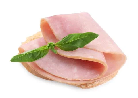 Piece of bread with tasty ham slice and basil isolated on white Stock Photos