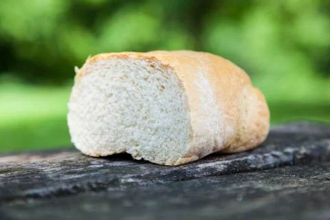 Piece of bread on wooden table Foto stock