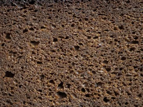 Piece of brown rye bread. Bread slice texture background Stock Photos