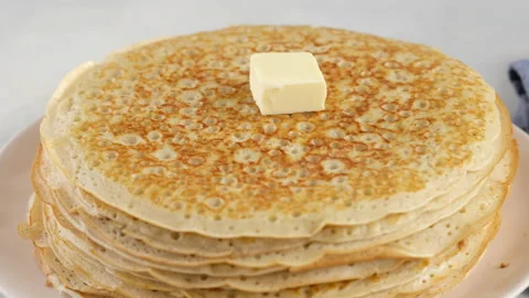 A piece of butter is placed on a stack of pancakes. Camera movement. Big round Stock Footage 145489394