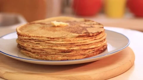A piece of butter on a stack of hot pancakes. Cooking pancakes at home Stock Footage 229640454
