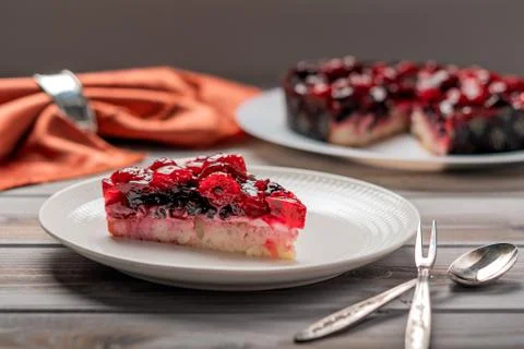 Piece of cake with berries: raspberry, currant, strawberry on a white plate Foto stock