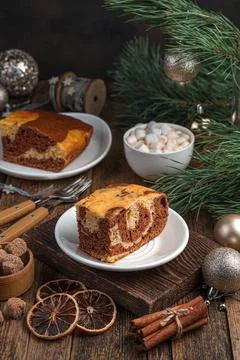 A piece of cake on a festive background with pine branches. Stock Photos
