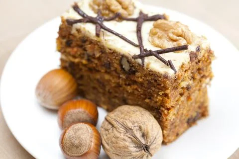 Piece of cake with nuts lying on the plate Stock Photos
