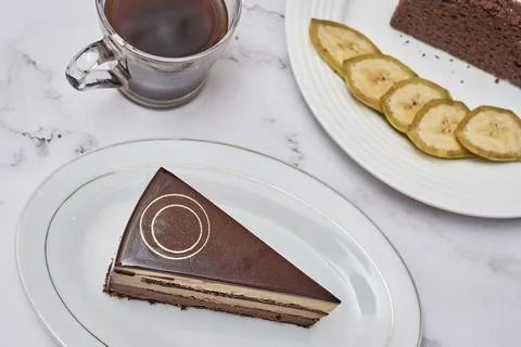 A piece of cake on a plate with a cup Stock Photos