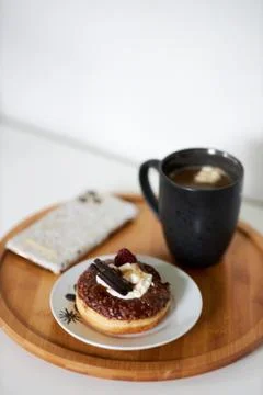 A piece of cake on a plate next to a cup of coffee Stock Photos